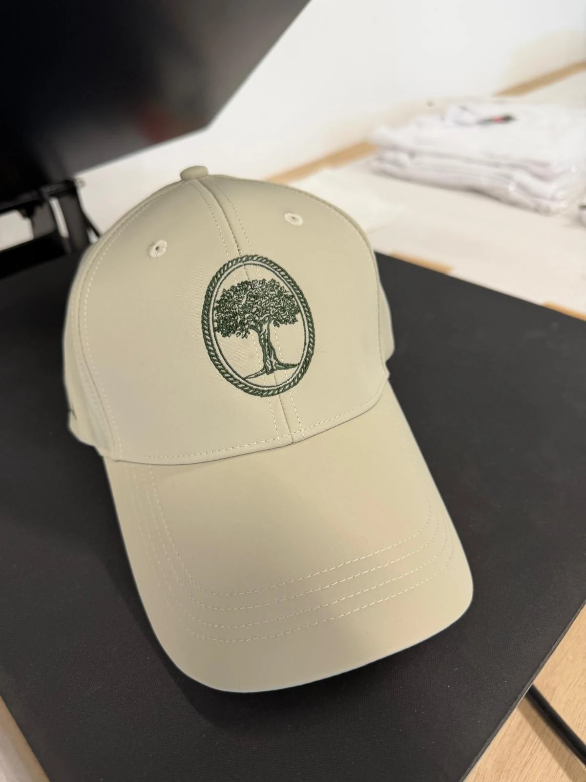 Motif d’arbre et contour ovale brodés sur une casquette beige