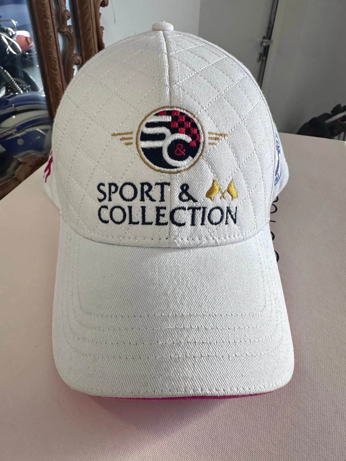 Logo Sport & Collection brodé sur le panneau frontal d’une casquette blanche